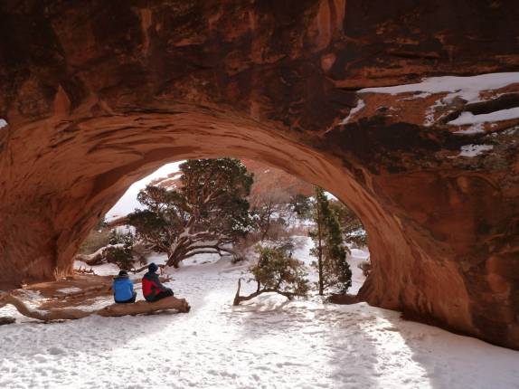 Turistas descansam sob o Navajo Arch, no Arches National Park, perto de Moab, em Utah, nos Estados Unidos
